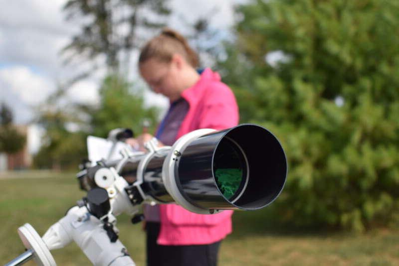 student setting up a telescope