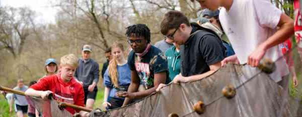 Students work with netting in a stream